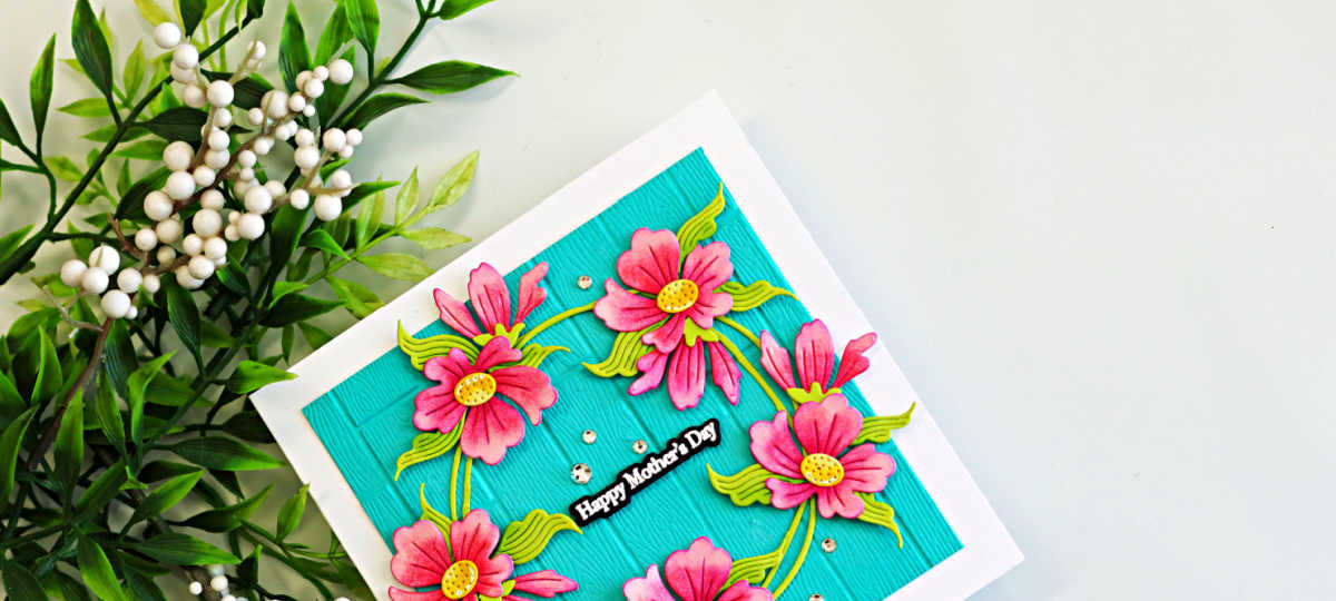 Don’t have the right color cardstock? Square Mother’s Day card featuring pink die cut flowers on Audrey Blue embossed cardstock with wooden plank texture and a Happy Mother’s Day sentiment.