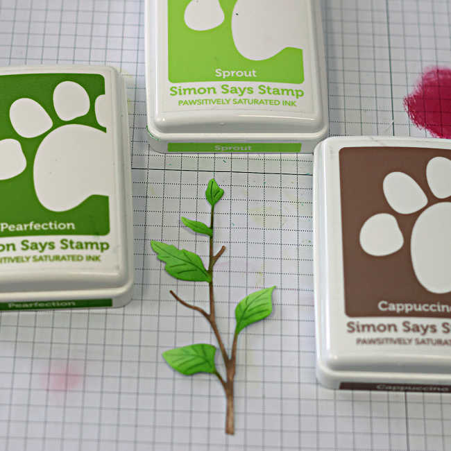 Ink blended die cut leaves and branch for a die cut spring card using green and brown inks.