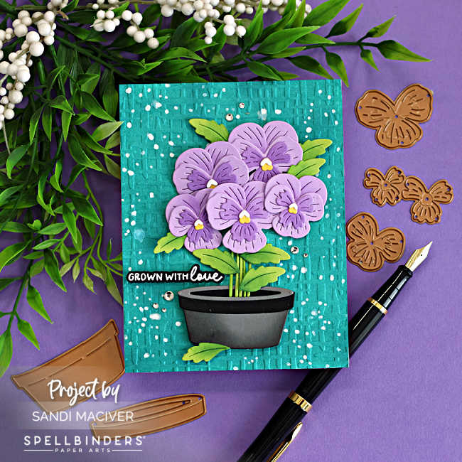 Fresh Packed floral card with layered die cut pansies in a pot, embossed Market Weave background, ink splatter and Spellbinders dies with coordinating pieces