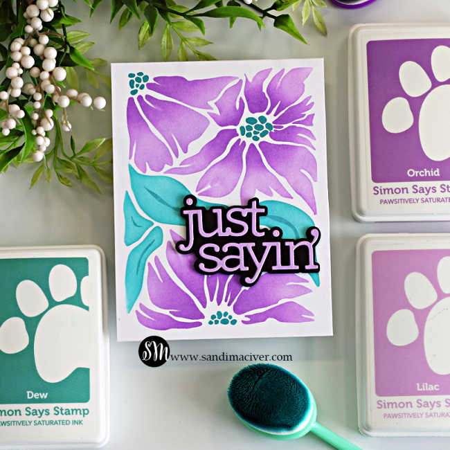 Simple ink blended card featuring the Friendly Blossoms stencil with purple flowers, teal leaves, and a layered “just sayin’” sentiment.