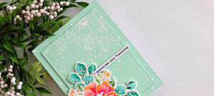 Messy watercolor wild rose card with soft mint green background, white embossed floral outline, and a layered hand-painted rose in coral and pink tones with teal leaves and sentiment strip.