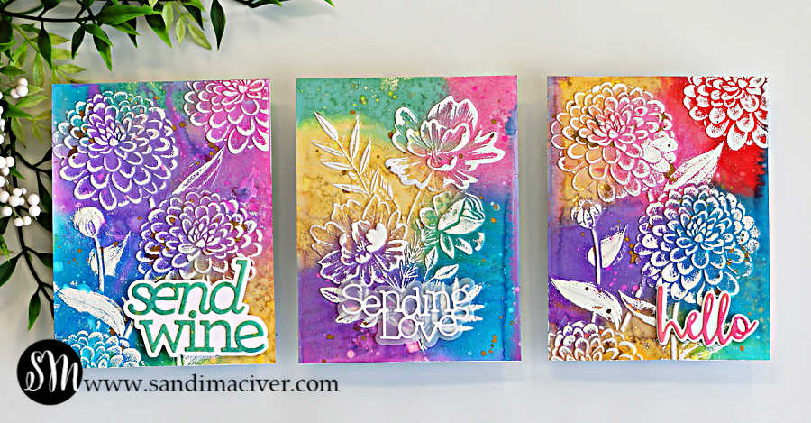 Three handmade cards using an embossing folder technique for cardmaking, featuring rainbow Distress Oxide ink backgrounds and white heat embossed floral designs with “Send Wine,” “Sending Love,” and “Hello” sentiments.