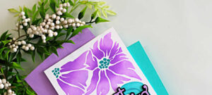 Simple ink blended floral card using the Friendly Blossoms stencil by Simon Says Stamp, featuring purple flowers and teal leaves on a clean white background.