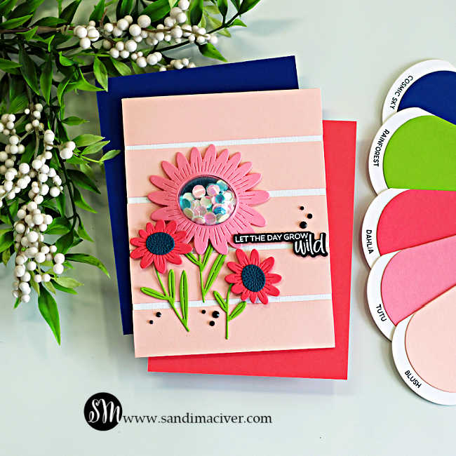 Soft cardmaking color combo featuring pink die cut flowers on a light blush background with green stems, blue centers, and a shaker flower detail for a subtle floral handmade card design.