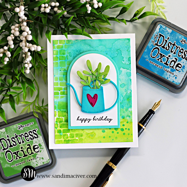 Watering can birthday card with ink smooshed Distress Oxide background, stenciled texture, and die cut foliage from Hero Arts My Monthly Super Hero April Kit.