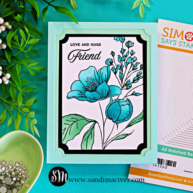 Handmade floral friendship card featuring turquoise blue flowers from the Wild and Free stamp set framed with layered black and mint A2 Notched Rectangle die cuts with a Love and Hugs Friend sentiment and Simon Says Stamp die packaging beside the card.
