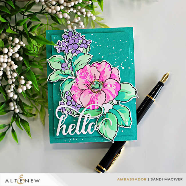 Bold spring floral card featuring layered stenciled pink and lavender flowers with mint green leaves, white paint splatter, and a large die cut hello sentiment on a rich teal card base.