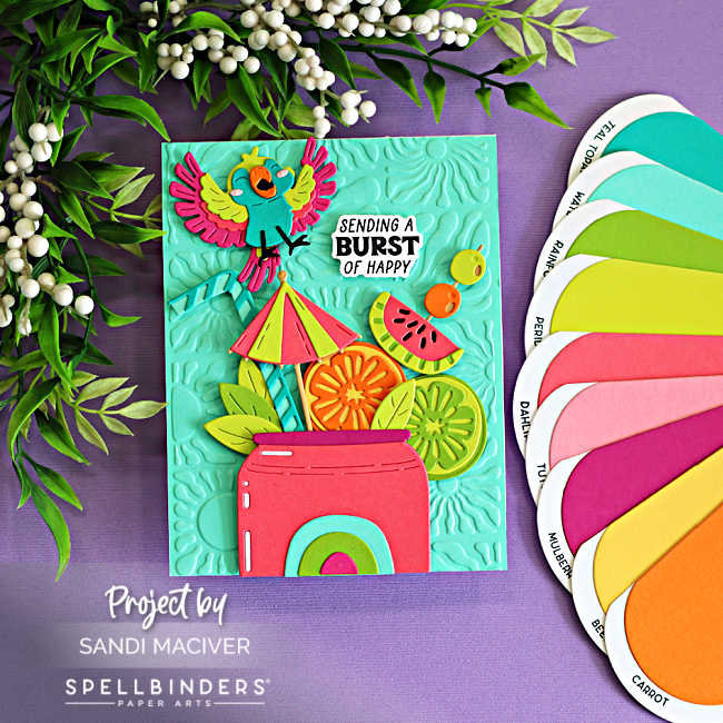 Bright Caribbean color combo card featuring tropical die cuts, citrus slices, watermelon, umbrella, and a colorful parrot created with the Spellbinders May Large Die of the Month. Coordinating cardstock swatches showcase the bold tropical palette against an aqua embossed background using the Radiant Day 3D Embossing Folder.