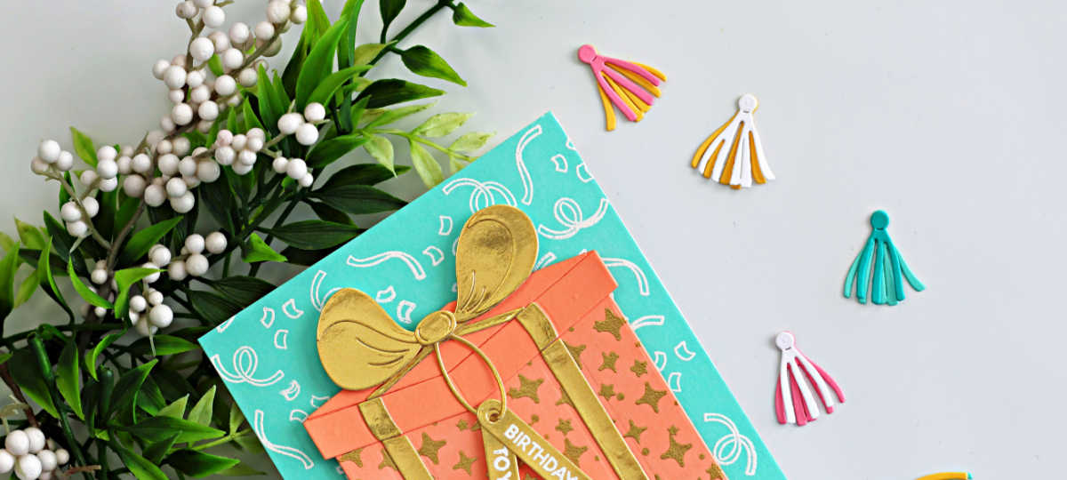 Handmade easy birthday card idea featuring the Hero Arts My Monthly Hero Big Present Die Set with peach and gold die cut gift box, gold heat embossing, aqua background, and colorful die cut tassel embellishments.