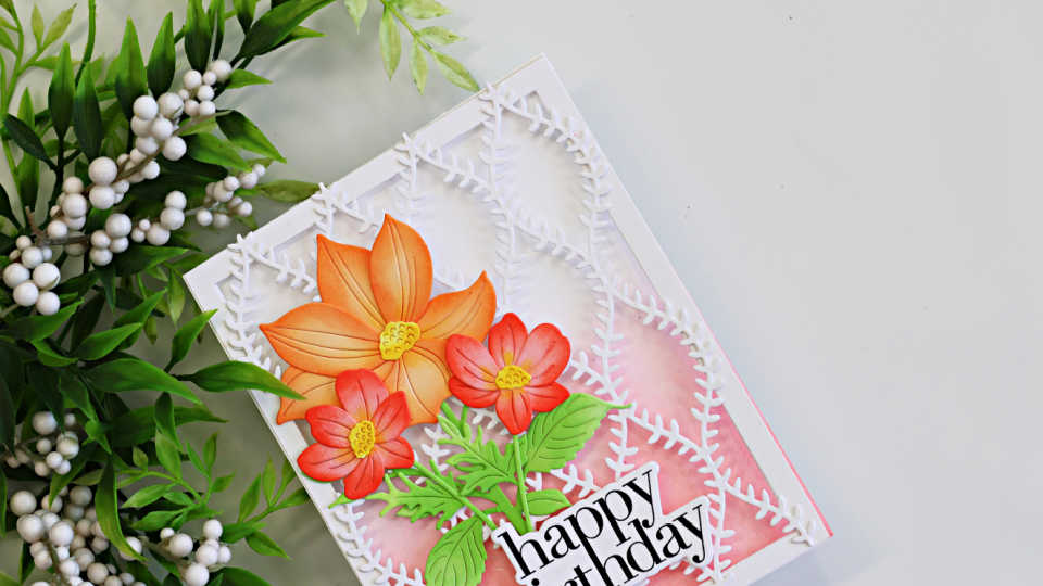 Peek-a-boo see-through floral birthday card featuring Simon Says Stamp Willowweave Plate layered over a soft pink background with ink blended Luna Flower and Sunblush Flowers dies in peach, coral, and green, finished with a bold happy birthday sentiment.
