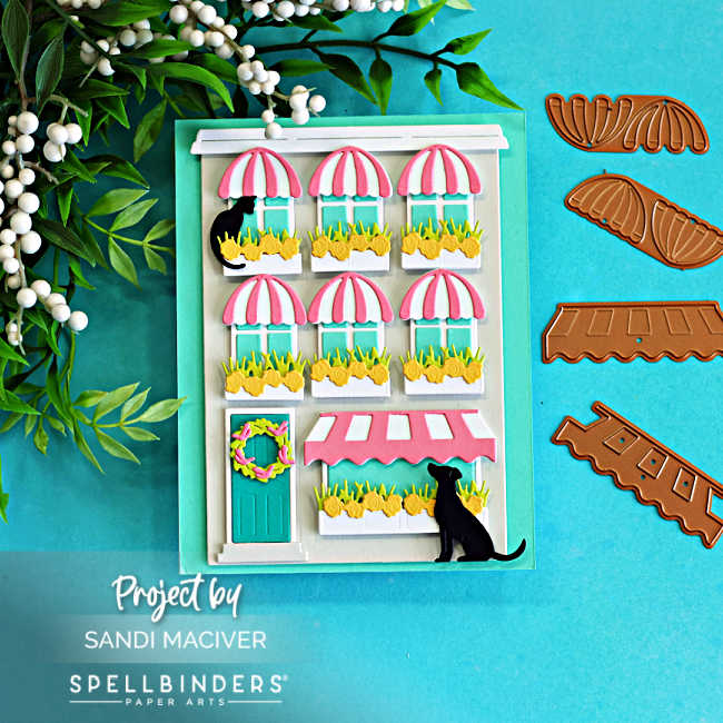 All die cut storefront card created with the Spellbinders Yana’s Everyday City Holiday dies featuring pink striped awnings, flower-filled window boxes, black cats, and layered dimensional details in Fog, Teal Topaz, Waterfall, Peridot, Tutu, and black cardstock.