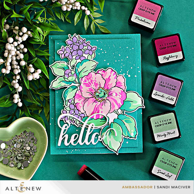 Spring floral card featuring layered stenciled pink and lavender flowers with mint green leaves, a large die cut hello sentiment, white splatter details, and coordinating Altenew ink colors on a deep teal background.
