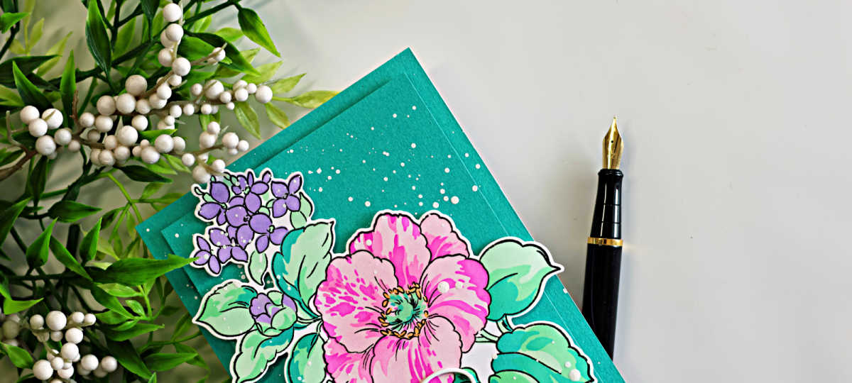 Spring floral card featuring layered stenciled pink and purple flowers with mint green leaves on a deep teal background with white splatter and fountain pen styling accents.