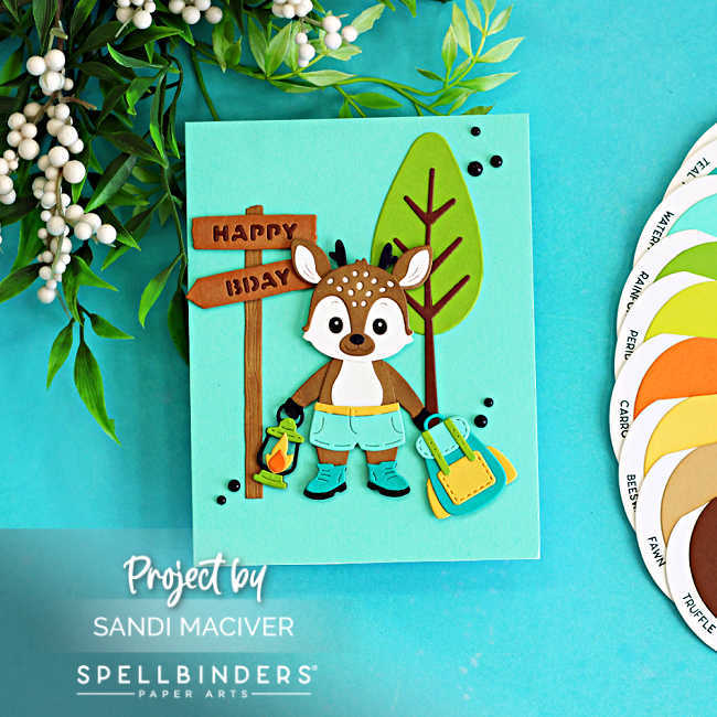 Cute summer camp birthday card featuring a layered die cut woodland deer holding a lantern beside a Happy Birthday sign and backpack, created with the Spellbinders Summer Camp Collection by Alli Fraser using teal, green, brown, yellow, and orange cardstock.