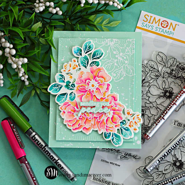 Handmade floral sympathy card featuring watercoloring with Karin Markers and the Simon Says Stamp Wild Rose stamp set, with bright pink and coral flowers, teal leaves, mint cardstock layers, and white splatter details on an aqua background.