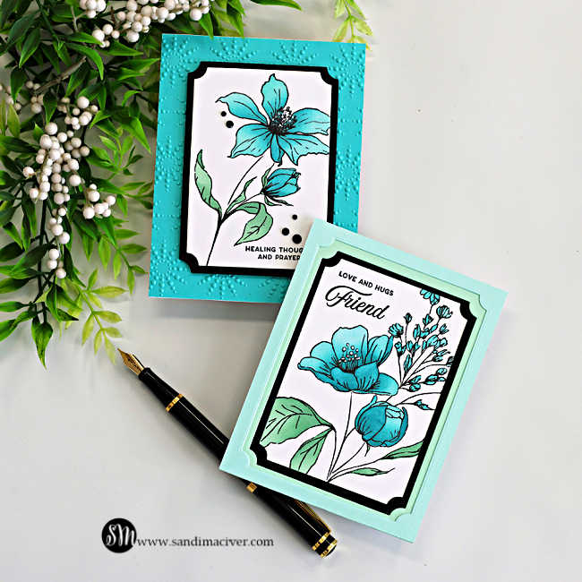 Two handmade floral cards featuring the Simon Says Stamp Wild and Free Flowers stamp set with turquoise and aqua blooms framed with black and white A2 Notched Rectangle die cuts on embossed turquoise and soft mint card bases, styled with greenery and a black fountain pen.