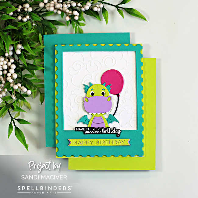 Handmade birthday card featuring the Spellbinders Party Time Dragon framed inside a teal polaroid-style die cut. The cute lime green and lavender dragon holds a bright pink balloon against a white embossed Cloud Nine background. Layered teal and Paridot cardstock create a colorful backdrop, while birthday sentiments add a playful finishing touch to this whimsical birthday card design.