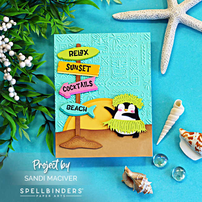 Handmade tropical beach card featuring a cute hula penguin wearing a grass skirt and headdress beside a colorful beach sign pointing to "Relax," "Sunset," "Cocktails," and "Beach." The scene includes a tropical sunset, sandy beach, and an aqua embossed background, styled with seashells, starfish, greenery, and glass gems on a bright turquoise backdrop.