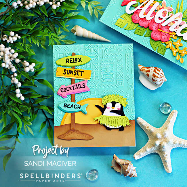 Handmade tropical beach card featuring a cute hula penguin wearing a grass skirt and headdress beside a colorful beach sign pointing to "Relax," "Sunset," "Cocktails," and "Beach." The scene includes a tropical sunset, sandy beach, and an aqua embossed background, styled with seashells, starfish, greenery, and glass gems on a bright turquoise backdrop.