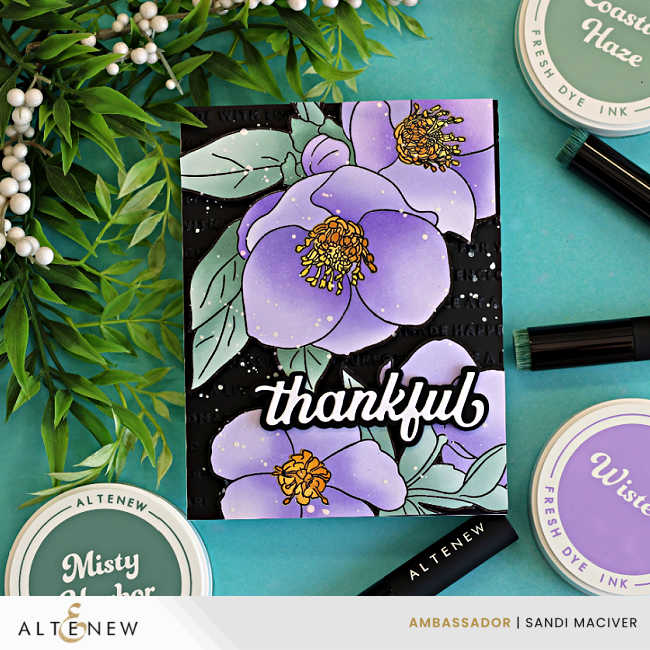 Handmade floral thank you card featuring large lavender flowers and soft mint green leaves from the Altenew Lenten Grace Stamp and Stencil Set. The florals are layered over a black embossed background with a bold white "thankful" sentiment. The card is photographed with Altenew ink pads and blending brushes on a turquoise background with decorative greenery.