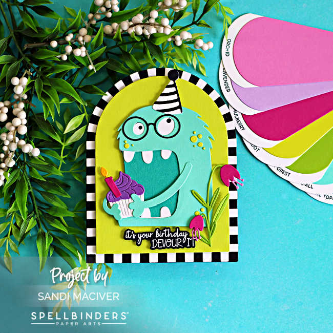 Colorful shaped birthday card featuring a turquoise Chompster monster holding a cupcake with a lit candle. The monster wears a black-and-white striped party hat and is framed inside a bright lime green arch with a striped border. Pink flowers and green foliage decorate the scene, while the sentiment reads, "It's your birthday, DEVOUR IT!" The card is photographed on a turquoise background with greenery and coordinating cardstock color swatches.