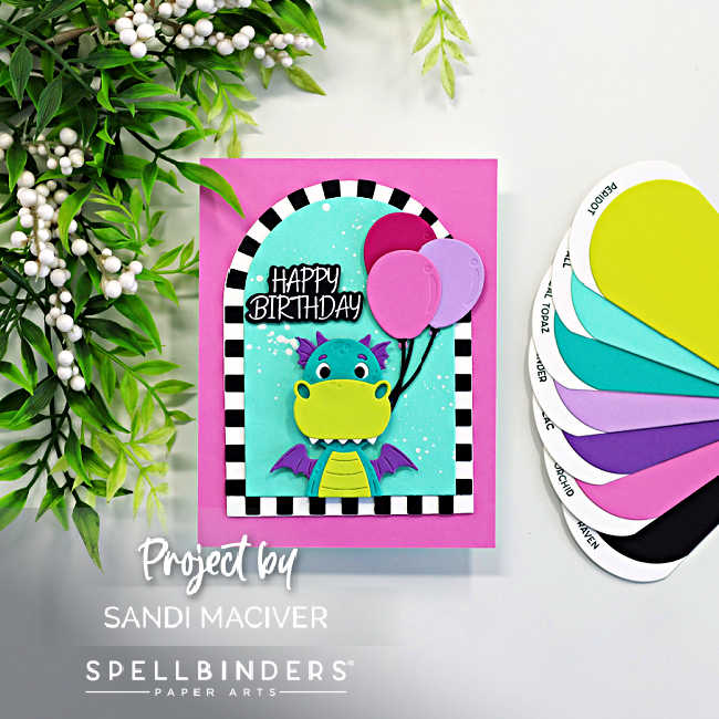 Bright and colorful dragon birthday card featuring the Spellbinders Party Time Dragon die set with a teal and lime dragon holding pink balloons inside a bold black and white striped arch frame on a vibrant pink card base with a happy birthday sentiment.