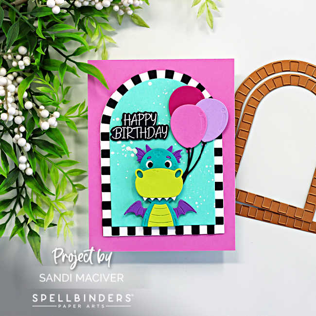 Bright and colorful dragon birthday card featuring the Spellbinders Party Time Dragon die set with a teal and lime dragon holding pink balloons inside a bold black and white striped arch frame on a vibrant pink card base with a happy birthday sentiment.