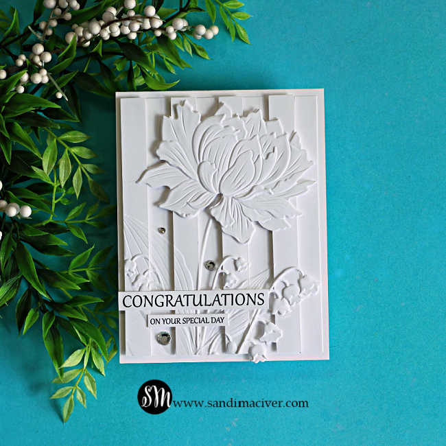 Elegant white-on-white embossed congratulations card featuring the Embossed Double Vision technique. A large layered flower and delicate floral accents are raised over dimensional vertical panels, creating rich texture and depth with a clean monochromatic design.