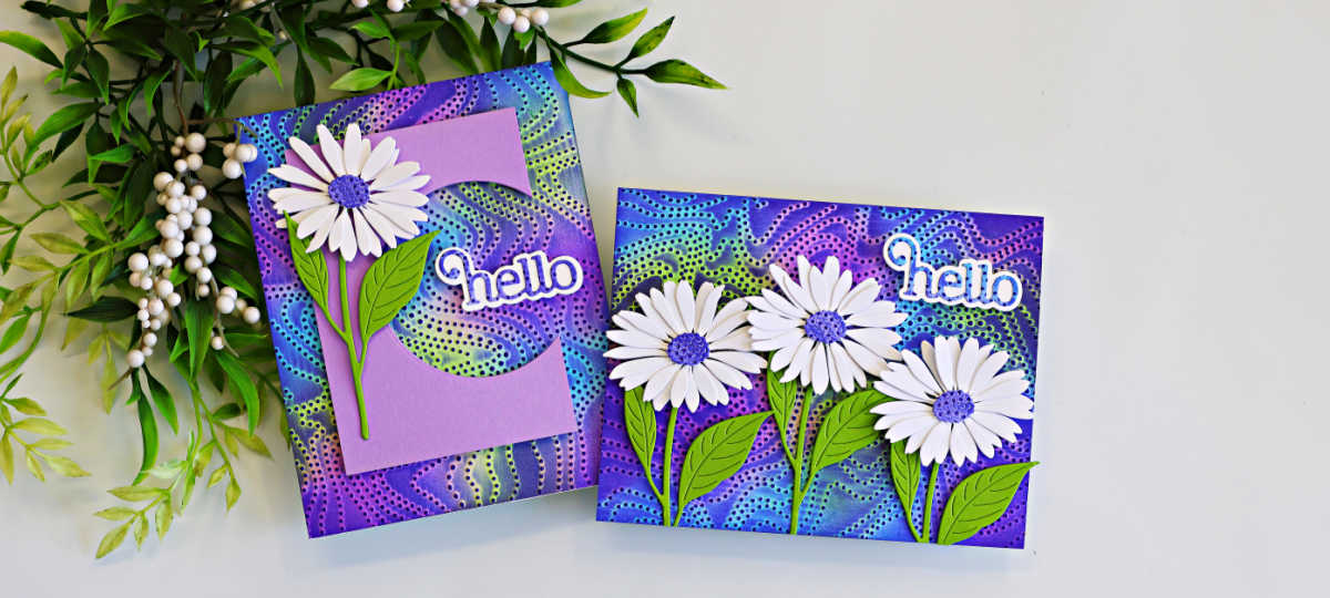 Two handmade greeting cards featuring the Embossed Joseph's Coat technique with the Dotty Contour Embossing Folder. The colorful embossed backgrounds blend shades of purple, blue, and lime green, accented with white daisy die cuts, green leaves, and layered "hello" sentiments. One card includes a lavender letter "C" monogram design, while the other showcases a trio of daisies.