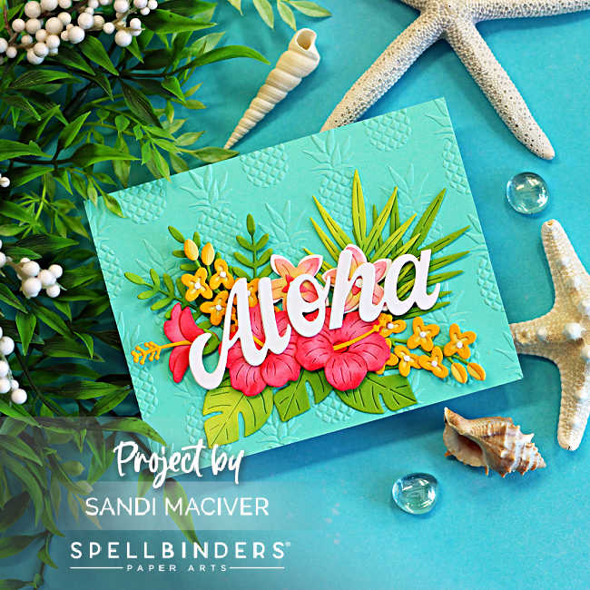 Handmade tropical Aloha card featuring bright pink hibiscus flowers, layered tropical foliage, and a large white "Aloha" sentiment on an aqua background embossed with a pineapple pattern. The card is photographed with starfish, seashells, greenery, and glass gems on a turquoise backdrop, creating a relaxing island-inspired beach scene.