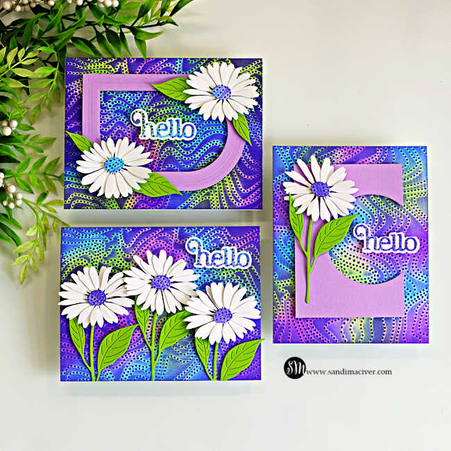 Three handmade greeting cards featuring the Embossed Joseph's Coat Technique with embossing folders. Each card showcases a vibrant ink-blended embossed background in shades of purple, blue, and green, accented with white daisy die cuts, green leaves, and layered "hello" sentiments in coordinating purple and blue tones.