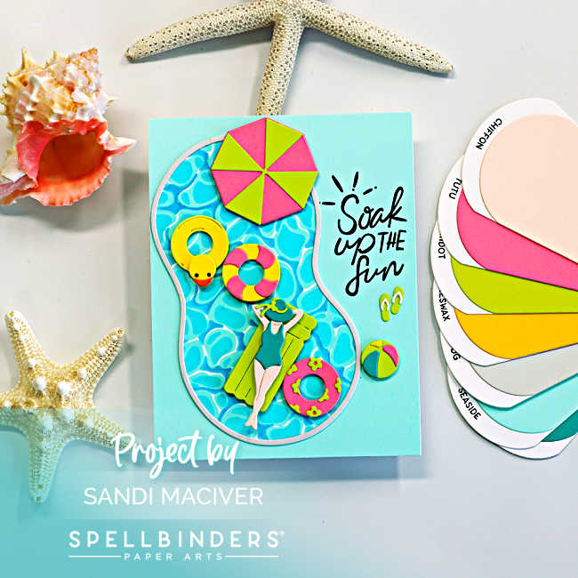 Handmade summer pool card featuring a die-cut swimming pool filled with bright aqua water, colorful floaties, a yellow rubber duck tube, beach umbrella, flip-flops, and a relaxing swimmer. The card includes the sentiment “Soak Up the Fun” on a soft aqua background with beach-inspired seashell and starfish accents.