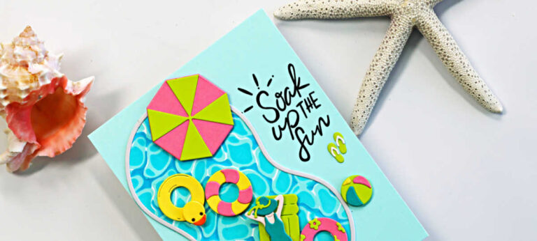 Bright and cheerful summer pool card featuring a blue swimming pool die cut filled with colorful floaties, including a yellow rubber duck tube, pink and lime life preservers, a beach umbrella, flip-flops, and a relaxing swimmer. The card includes the sentiment “Soak Up the Fun” on a soft aqua background with beach-inspired seashell and starfish props.