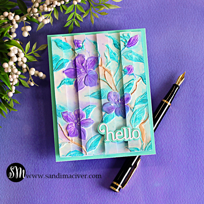 Handmade floral card featuring the Faux Watercolor Embossed Double Vision technique with purple flowers, aqua embossed leaves, dimensional vertical panels, and a layered "hello" sentiment on a turquoise card base.