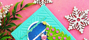 Close-up of a handmade Christmas card featuring a black and white cat climbing a decorated Christmas tree beside an arched window with a starry night sky. The aqua embossed background is created with the Spellbinders A2 Herringbone Décor Embossing Folder and includes a "Have a Purrfect Christmas" sentiment.
