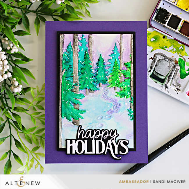 Handmade holiday card featuring a snowy forest scene created with the Altenew Snowy Footpath Embossing Folder and a simple watercolor technique. Evergreen trees, birch trunks, and a winding snow-covered path are painted in soft watercolor shades and layered onto a rich purple card base. A bold black-and-white "happy Holidays" sentiment completes the design, with watercolor paints and a paintbrush visible beside the card.