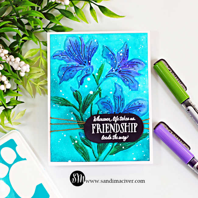 Handmade floral friendship card featuring blue Alstroemeria blooms watercolored with Karin Markers on a bright teal background, finished with white splatter, gold thread and a friendship sentiment.