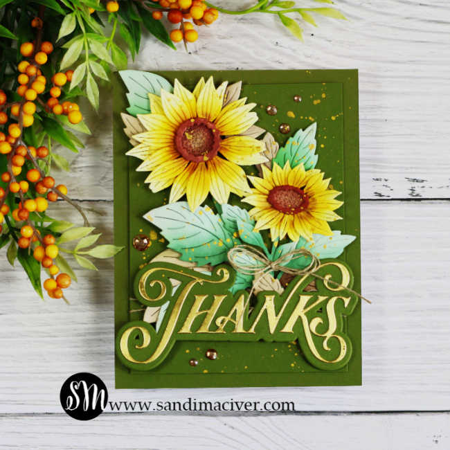 Sunflower thank you card with layered yellow blooms, aqua green leaves, gold accents, twine, and an oversized gold Thanks sentiment on a deep olive green background.