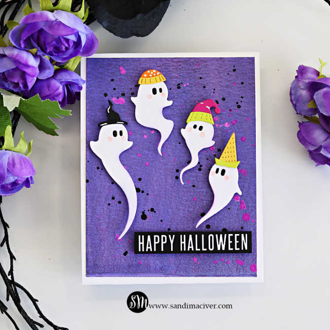White Halloween card featuring four adorable swirling ghosts wearing colorful hats on a purple Distress Oxide spray background with black and bright pink splatters, finished with a bold Happy Halloween sentiment.