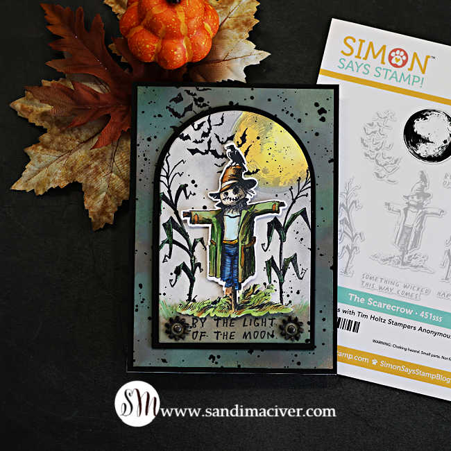 Tim Holtz The Scarecrow Halloween card featuring the new coordinating dies, with a colorful die-cut scarecrow against a moonlit cornfield, flying bats and distressed background.