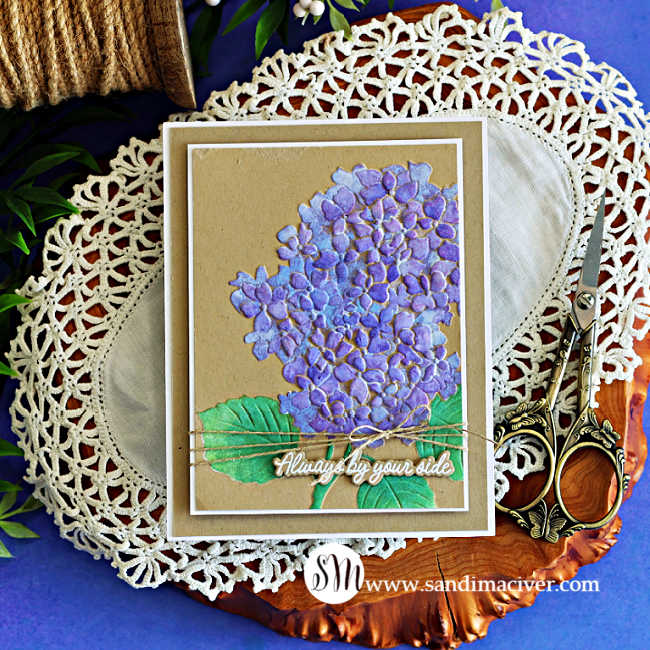 Handmade hydrangea card featuring purple stenciled flowers and green leaves on Kraft cardstock, layered with a white mat and finished with natural twine and an “Always by your side” sentiment.