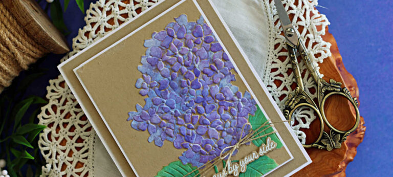 Handmade hydrangea card featuring purple stenciled flowers and green leaves on Kraft cardstock, layered with a white mat and finished with natural twine and an “Always by your side” sentiment.