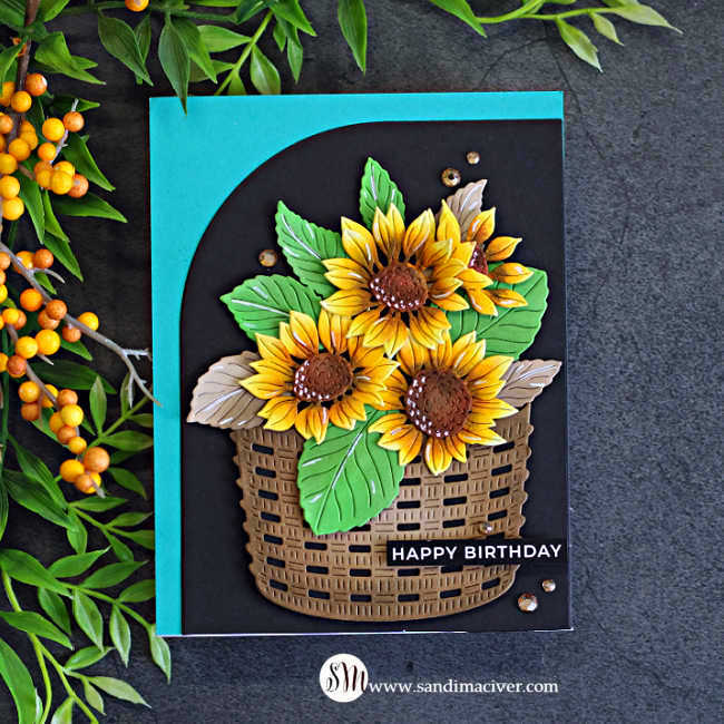 Handmade birthday card featuring golden yellow sunflowers and green leaves in a woven basket, layered over a black Squarevel die-cut mat with a teal card base.