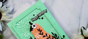 Mint green and coral Harvest Heirloom birthday card featuring an embossed Pumpkin Wreath background, black leafy accents, white flowers, and a framed Happy Birthday sentiment.