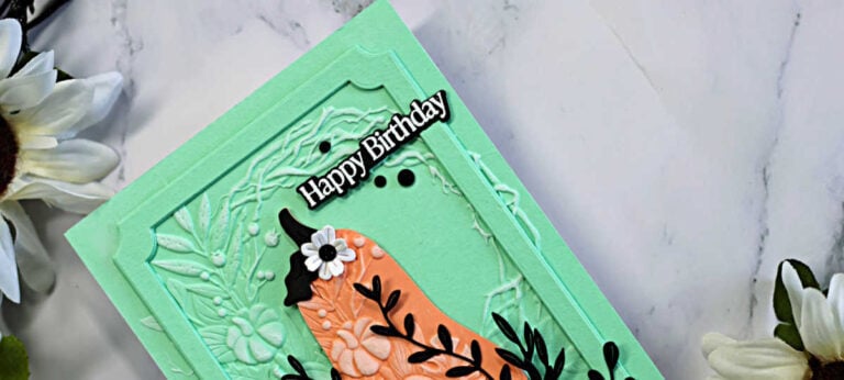 Mint green and coral Harvest Heirloom birthday card featuring an embossed Pumpkin Wreath background, black leafy accents, white flowers, and a framed Happy Birthday sentiment.