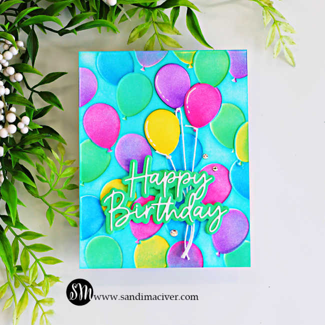 Colorful handmade birthday card featuring embossed pink, purple, green, yellow, and blue balloons on a turquoise background, with a layered Happy Birthday sentiment and rhinestone accents.