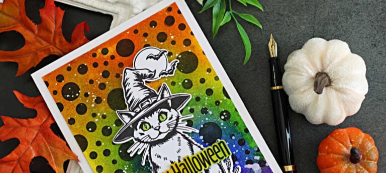 Halloween card featuring a witch-hat cat on a colorful Distress Spray background with black polka dots, bats, and a Happy Halloween sentiment.