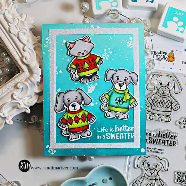 Simon Says Stamp and Newton’s Nook Sweater Season card featuring three Copic-colored critters in colorful sweaters on an aqua snowflake background with a sparkly frame.