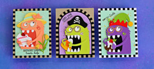 Three handmade cards featuring Chompster new accessories: coral Mrs. Chompster with birthday cake, a lime green Halloween pirate with candy corn, and a purple Christmas elf with pudding, each framed by a checkerboard border.