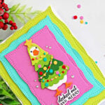 Handmade Christmas card featuring a silly goose dressed as a Christmas tree, framed by colorful stitched zigzag panels, created with the Spellbinders Lit with Joy dies.